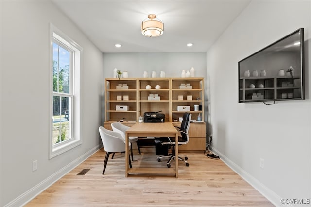 office space featuring plenty of natural light and light hardwood / wood-style floors