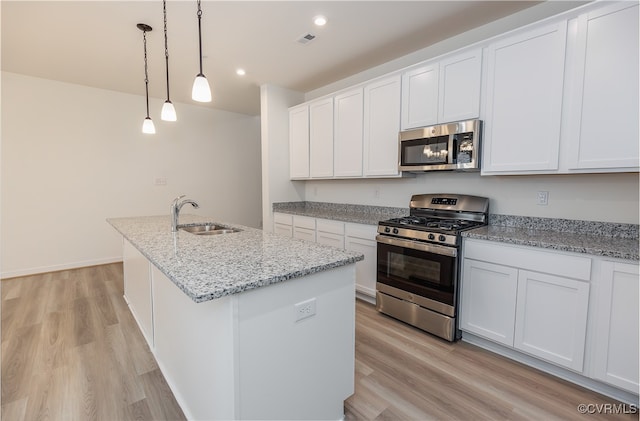 kitchen with white cabinetry, sink, stainless steel appliances, an island with sink, and pendant lighting