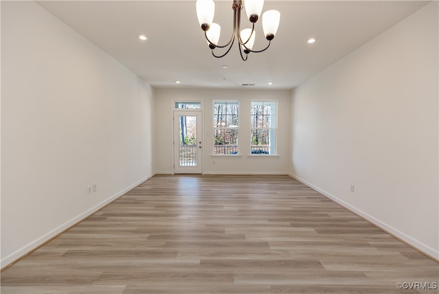 unfurnished dining area featuring light hardwood / wood-style flooring and an inviting chandelier