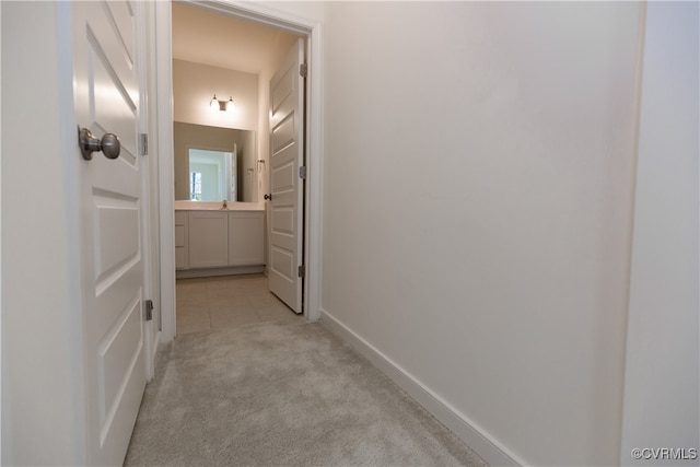 hall featuring light carpet and sink