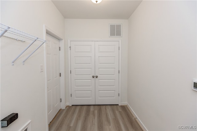 hallway with light hardwood / wood-style floors