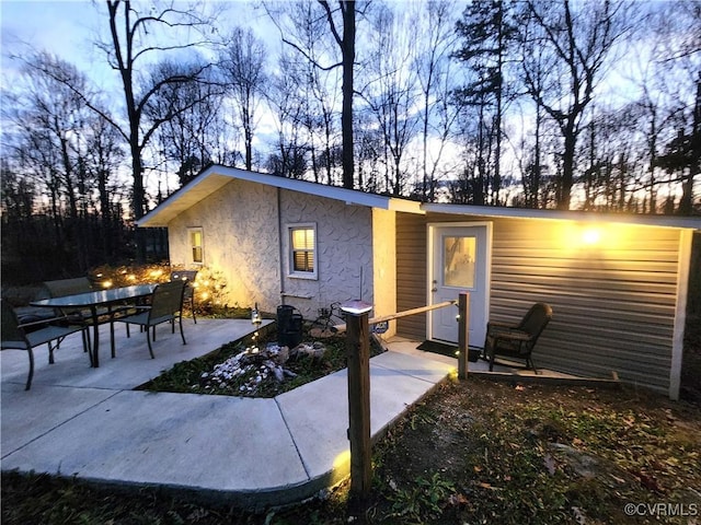 back house at dusk with a patio area