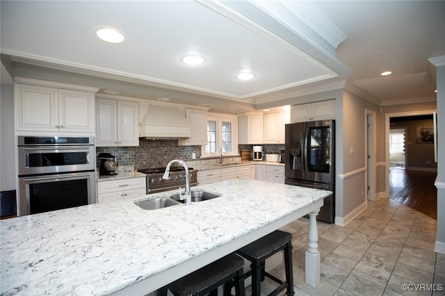 kitchen with premium range hood, ornamental molding, double oven, sink, and refrigerator with ice dispenser