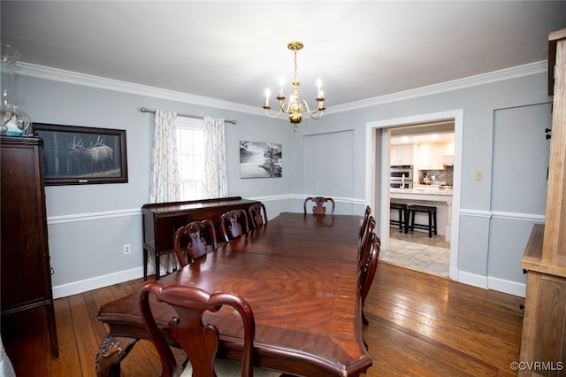 dining area featuring crown molding, an inviting chandelier, and light wood-type flooring