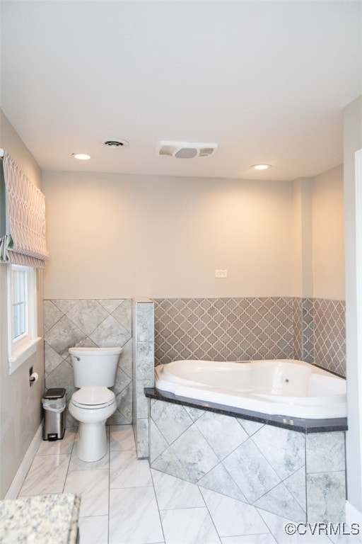 bathroom featuring toilet, tile walls, and tiled tub