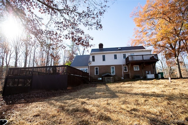 rear view of house featuring a yard and a wooden deck