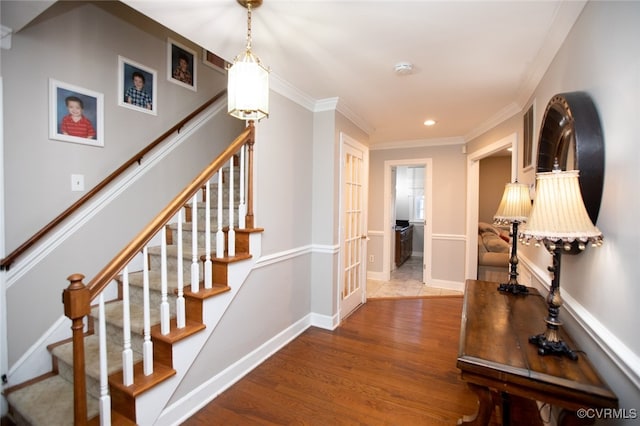 entrance foyer with wood-type flooring and ornamental molding