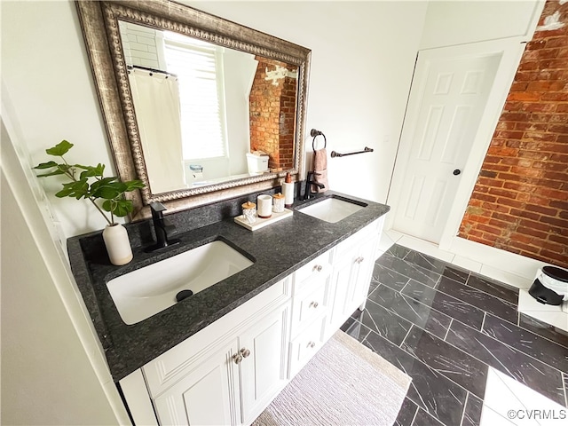 bathroom with vanity and brick wall