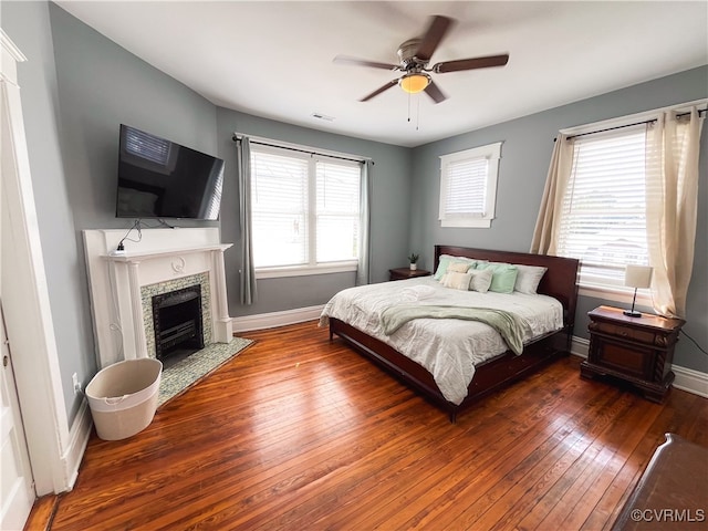 bedroom with dark hardwood / wood-style flooring, multiple windows, and ceiling fan