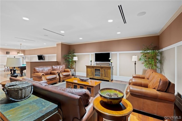 living area featuring ornamental molding and recessed lighting