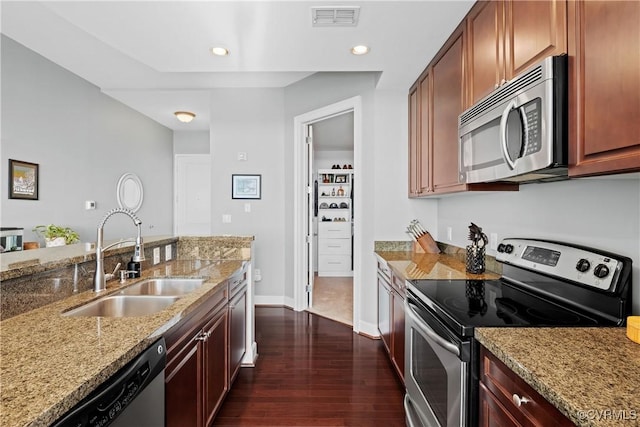 kitchen with dark wood-style flooring, visible vents, appliances with stainless steel finishes, a sink, and light stone countertops