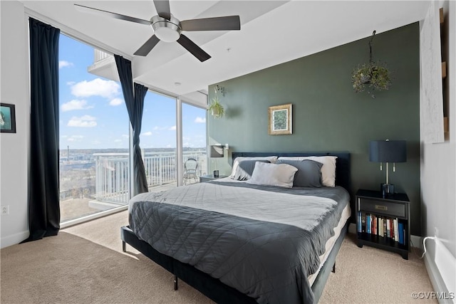 carpeted bedroom featuring expansive windows, access to outside, a ceiling fan, and baseboards