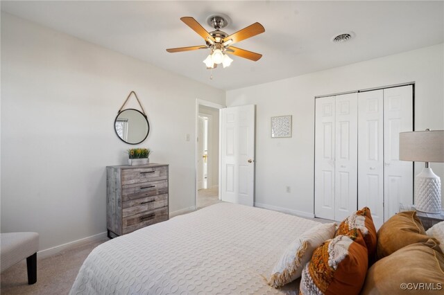 bedroom with ceiling fan, a closet, and light colored carpet