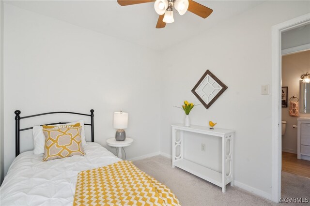 bedroom featuring ceiling fan, ensuite bathroom, and light carpet