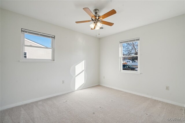 empty room with light carpet, ceiling fan, and a healthy amount of sunlight