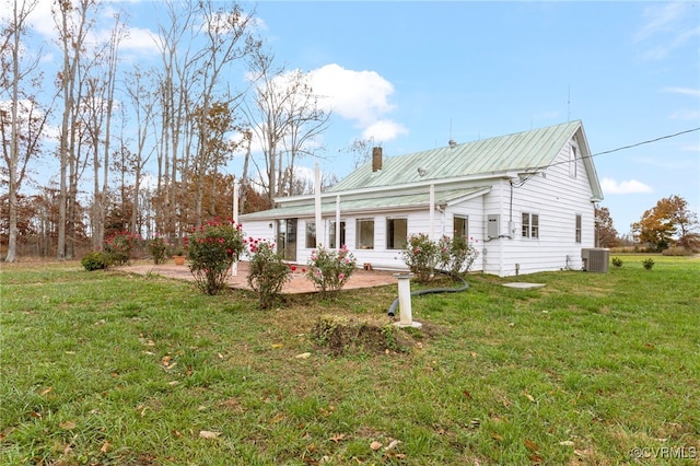 rear view of property with a yard, a patio area, and central air condition unit