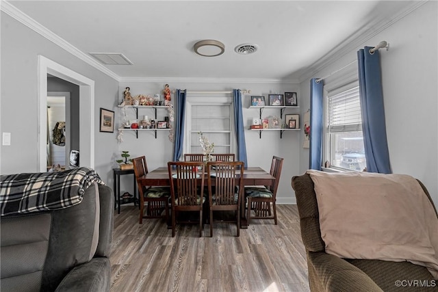 dining space with crown molding and wood-type flooring