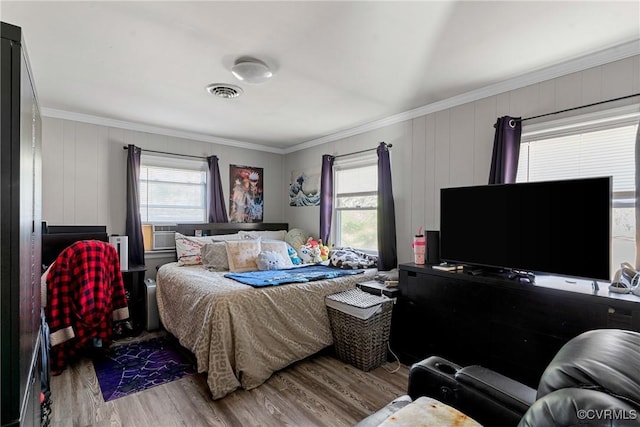 bedroom featuring light hardwood / wood-style flooring, cooling unit, and crown molding