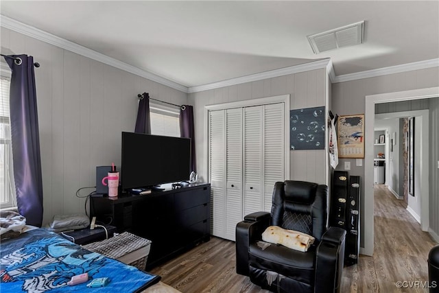 bedroom featuring dark hardwood / wood-style floors, crown molding, and a closet