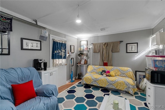 bedroom featuring light wood-type flooring and crown molding