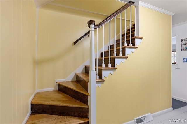 stairway with tile patterned flooring and crown molding