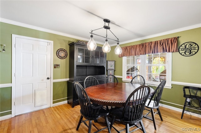 dining space with wood-type flooring and ornamental molding