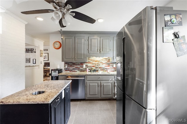 kitchen featuring tasteful backsplash, gray cabinetry, sink, and stainless steel appliances