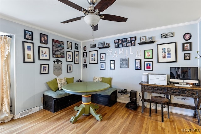 dining area with light wood-type flooring, breakfast area, ceiling fan, and crown molding