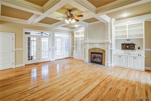 unfurnished living room featuring a fireplace, beam ceiling, light hardwood / wood-style floors, and coffered ceiling