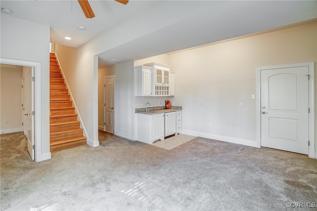 unfurnished living room with ceiling fan and light carpet