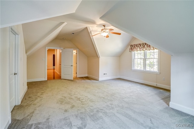 additional living space with ceiling fan, light colored carpet, and lofted ceiling