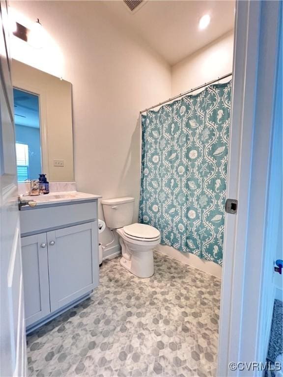 bathroom featuring a shower with curtain, vanity, and toilet