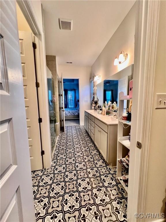 bathroom with vanity and a shower with door