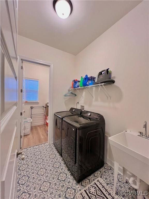 laundry area with separate washer and dryer, sink, and light wood-type flooring