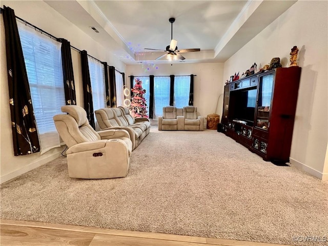 carpeted living room featuring ceiling fan and a tray ceiling