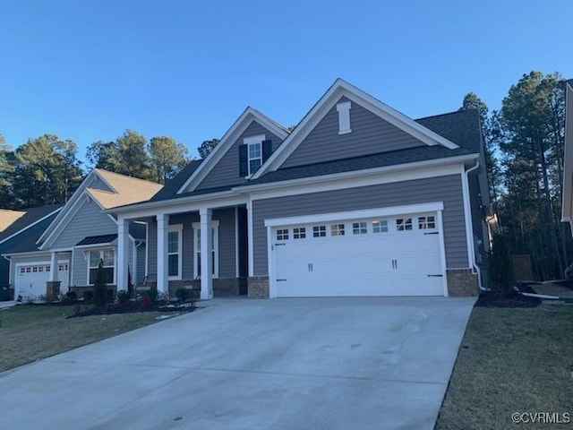 craftsman-style home with a garage, a front lawn, and covered porch