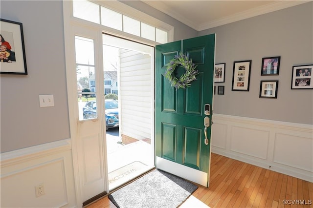 foyer featuring light wood-type flooring and crown molding