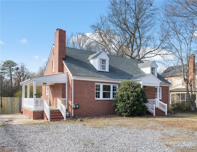 cape cod home featuring covered porch