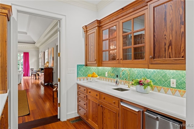 kitchen featuring dishwasher, backsplash, sink, crown molding, and light hardwood / wood-style floors