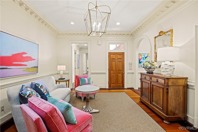 living room featuring crown molding, hardwood / wood-style floors, and a chandelier