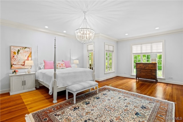 bedroom featuring hardwood / wood-style floors, a notable chandelier, and ornamental molding