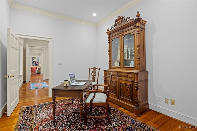 living area featuring wood-type flooring and ornamental molding