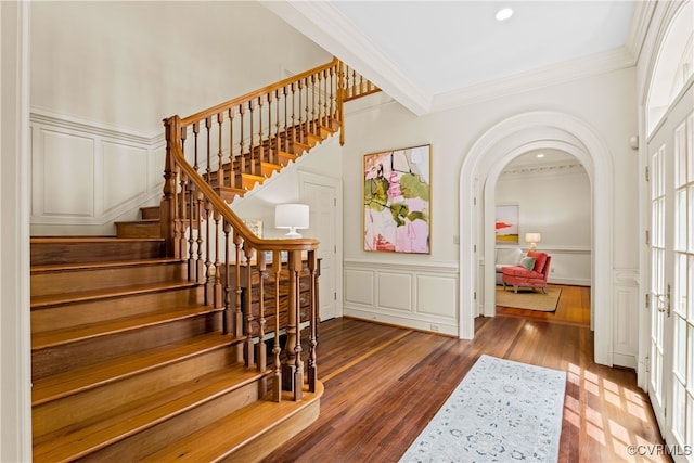 staircase featuring crown molding and hardwood / wood-style floors