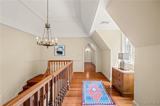 hall with light hardwood / wood-style flooring and a chandelier