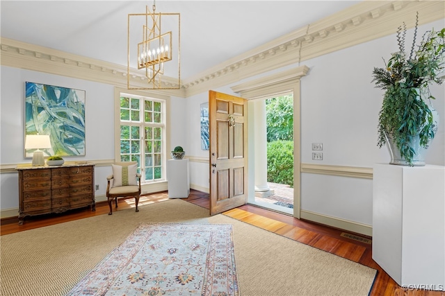 doorway with hardwood / wood-style floors, a chandelier, and ornamental molding