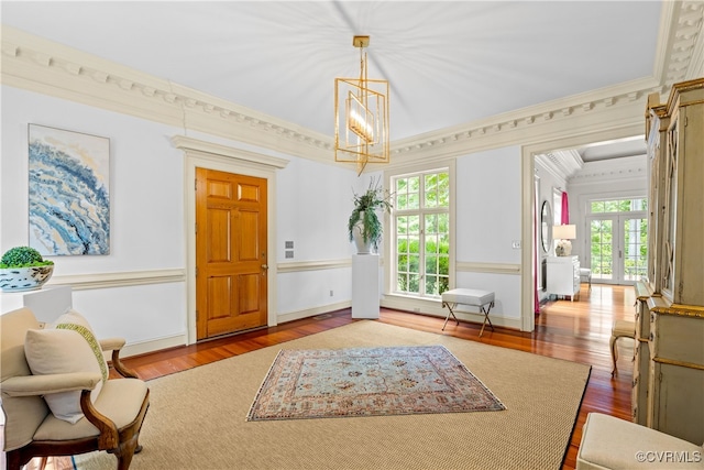 interior space with a chandelier, crown molding, french doors, and wood-type flooring