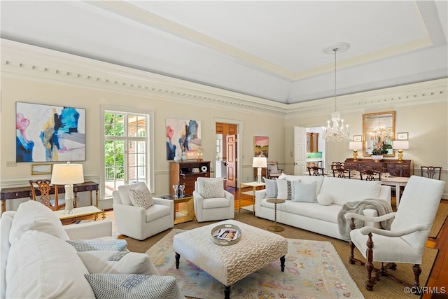 living room with a raised ceiling, a notable chandelier, and ornamental molding