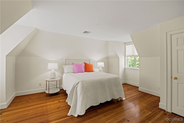 bedroom featuring wood-type flooring and vaulted ceiling