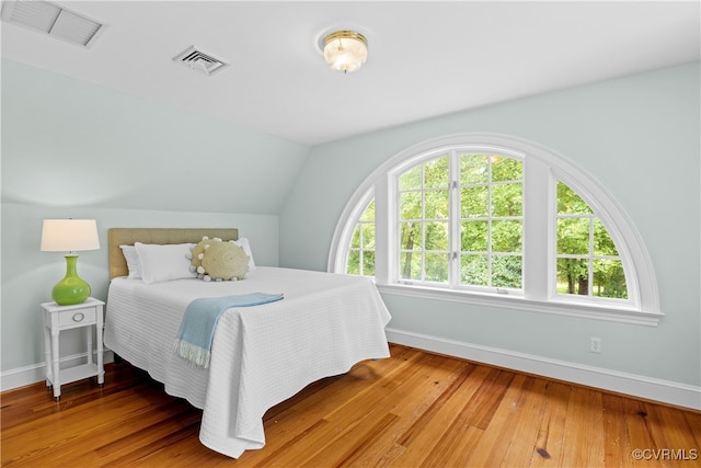 bedroom featuring wood-type flooring and vaulted ceiling