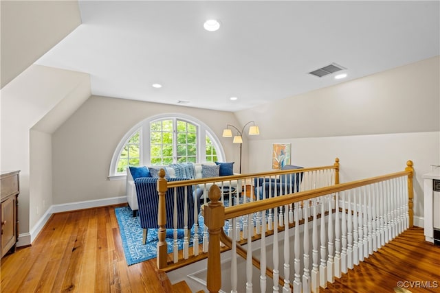 bonus room with light wood-type flooring and vaulted ceiling